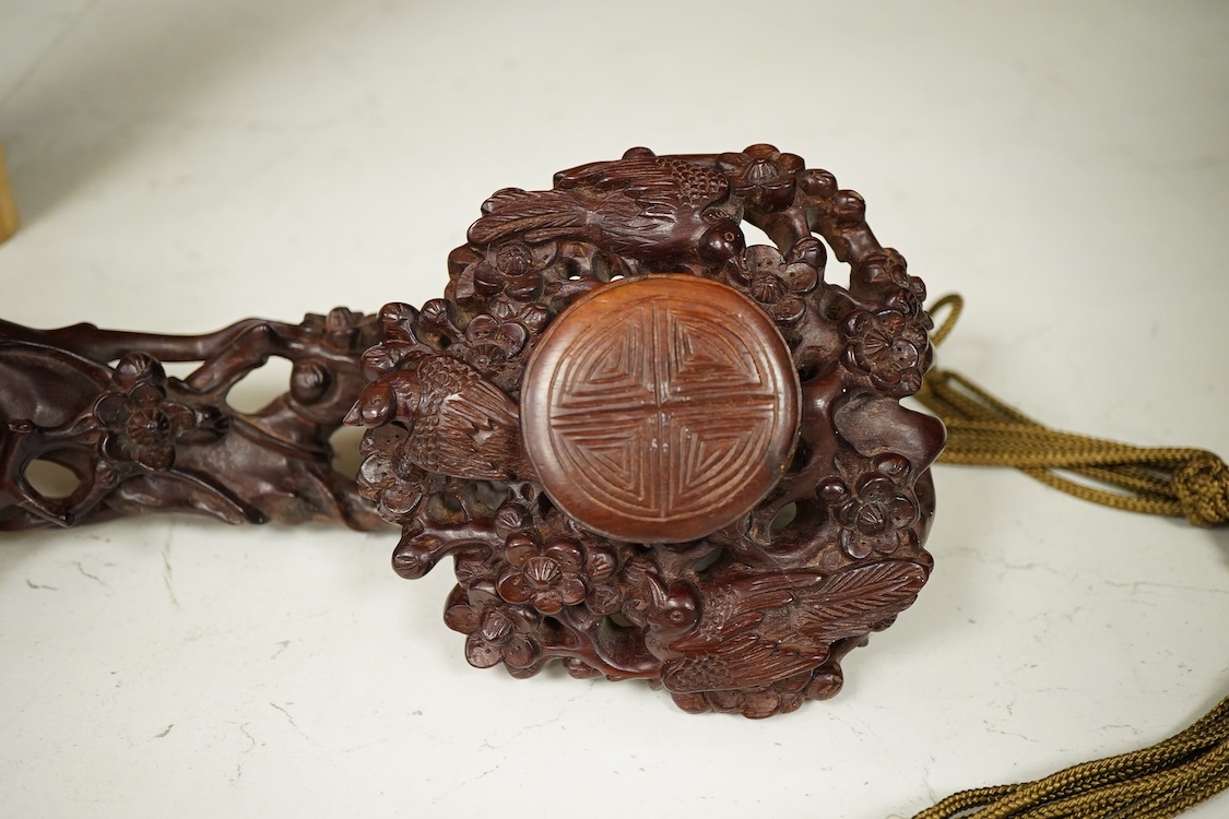 A Chinese carved hardwood Ruyi sceptre, with two porcelain ‘dragon’ beads, 50cm in length